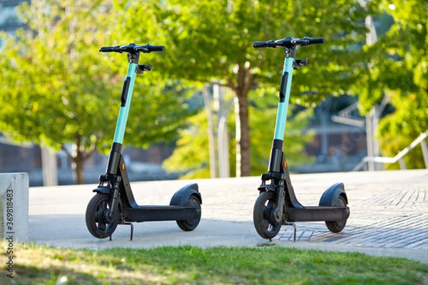 Obraz two new electric scooter parking in the city by sunlight
