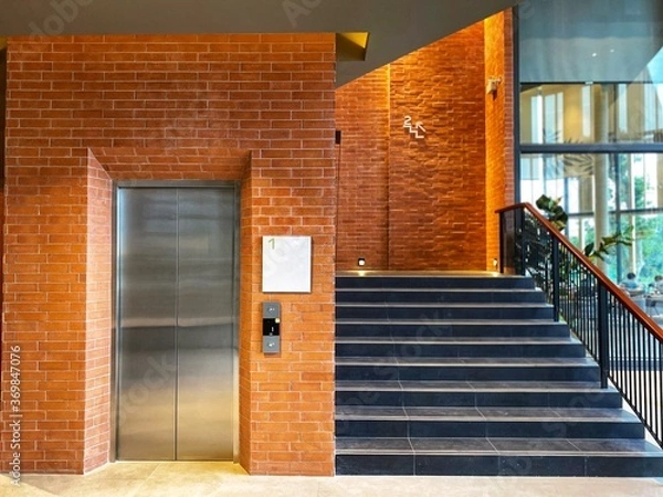 Obraz Elevator and fire escape, decorated with red brick walls.