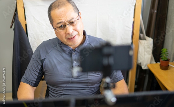 Obraz オンラインミーティング中に眉間にしわを寄せて首をかしげる男性