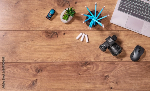 Fototapeta Photographers and graphic designers workplace. Flat lay top view of  desk with laptop, camera. Wooden table copy space.