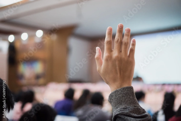 Fototapeta Audience or students raising hands up at conference to answer question while speaker speech at seminar hall with crowd groups, arms of large group in classroom for vote or questions