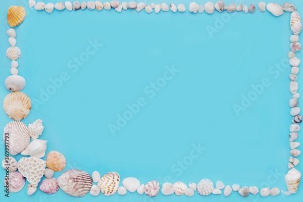 Fototapeta blue background in a frame of light shells and small white stones