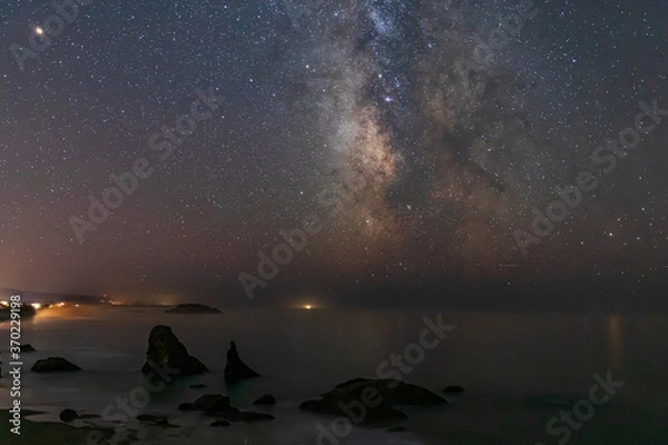 Fototapeta Milky Way galaxy shines in the sky above Bandon Beach in Oregon