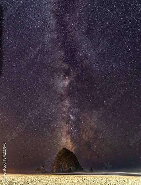 Obraz Vertical Image-Milky Way galaxy shines in the sky above Haystack Rock on Cannon beach in Oregon