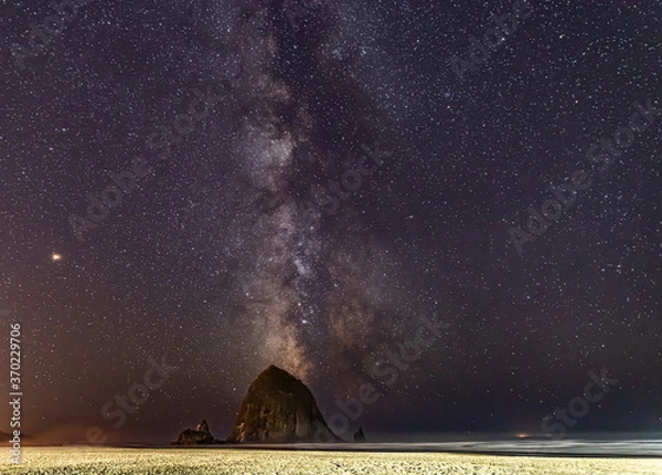 Obraz Milky Way shines in the sky behind Haystack Rock on Cannon Beach in Oregon