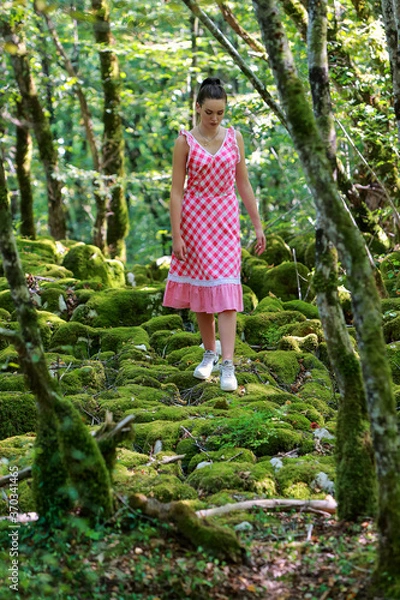 Fototapeta Jeune femme en robe à carreau se promenant dans les bois en été