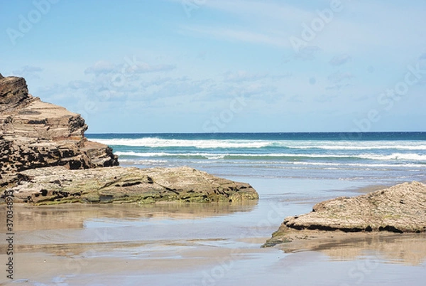 Obraz swell between the big rocks in the blue sea