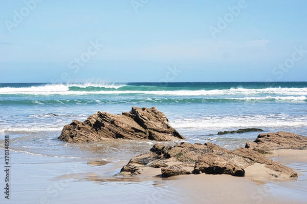 Obraz swell between the big rocks in the blue sea