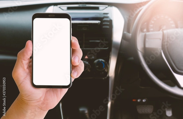 Fototapeta Smartphone with blurred background of car steering wheel