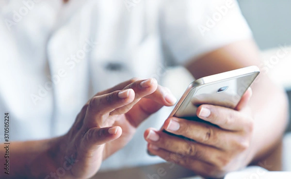 Fototapeta Closeup of a man hand using a smartphone
