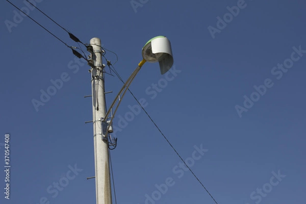 Fototapeta It is a pole and a street light on the background of the blue sky.