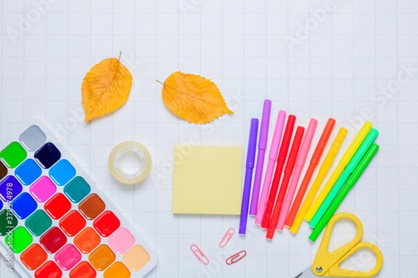 Obraz School supplies on a white checkered paper background. Back to school. New academic year begin. Place for text.Stationery set.Teacher's Day. Autumn