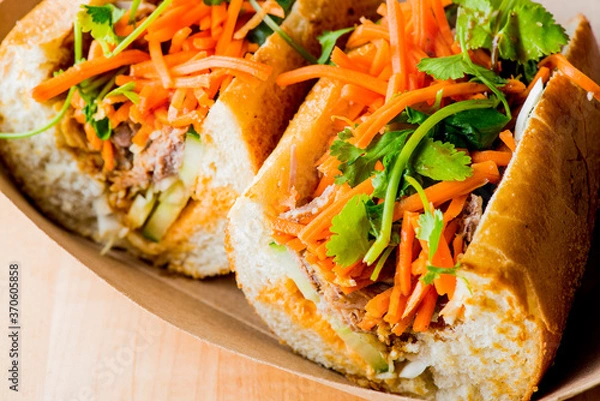 Fototapeta Bánh mì or banh mi, Vietnamese word for bread. Traditional classic Vietnamese cuisine. Baguette with pate, pulled pork, jalapenos, cilantro, carrots cucumbers and spicy sauce.