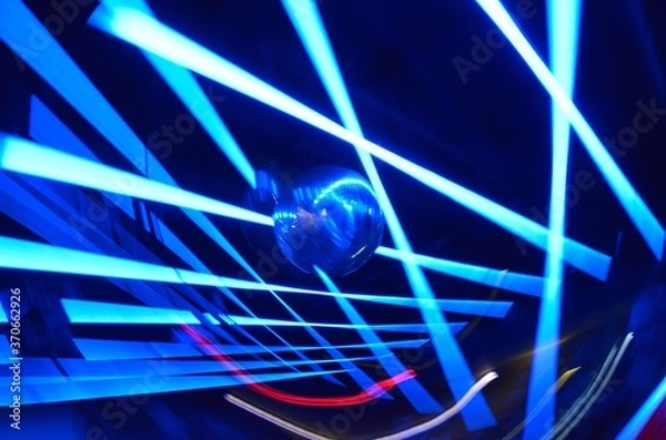 Obraz Long exposure photo of a mirroball, color LED and Neon lights with camera motion and dark background