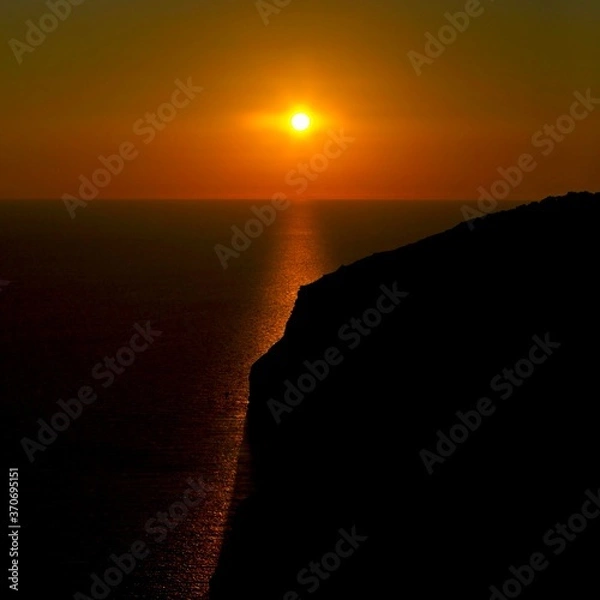 Fototapeta A beautiful sunset over calm Mediterranean waters at Dingli Cliffs in Malta