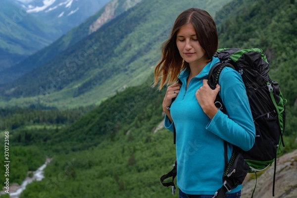 Fototapeta Backpacker on top of a mountain enjoying valley view