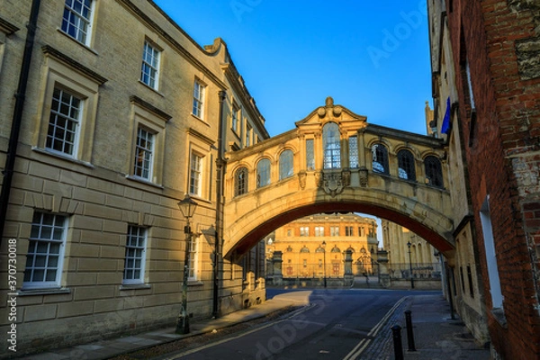Obraz Hertford Bridge, Bridge of Sighs, in Oxford at sunrise with Sheldonian Theatre behind it and no people around, early in the morning on a clear day with blue sky. Oxford, England, UK.