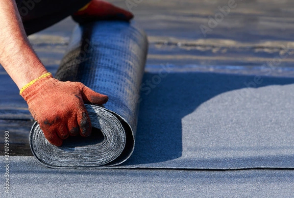 Obraz Worker puts roofing material