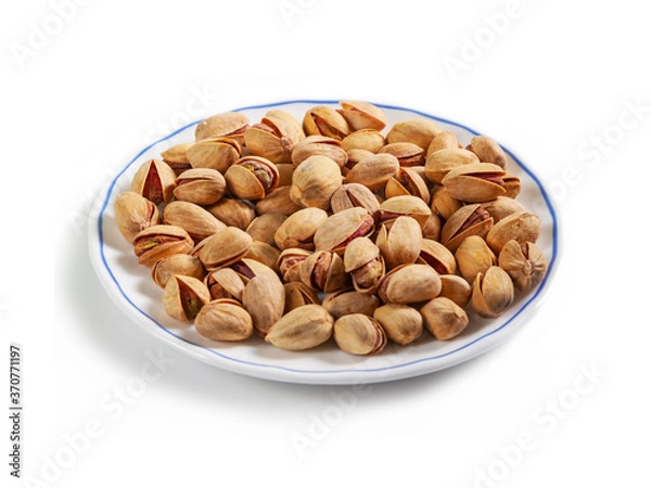 Fototapeta salted pistachios in a shell on a white saucer with a blue border, isolated on a white background
