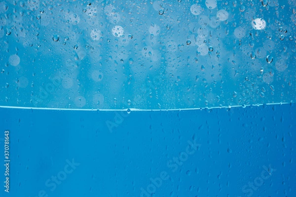 Obraz Krople wody niebieskie tło. Niebieska woda spada na tle szkła łodzi.