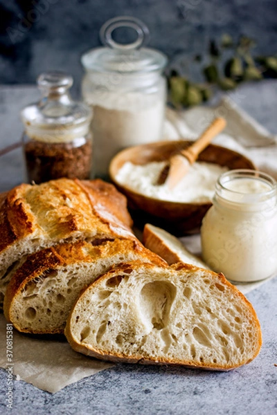 Fototapeta Artisan sourdough bread cut into slices on a dark background close-up, vertical background.Slices of bread close up