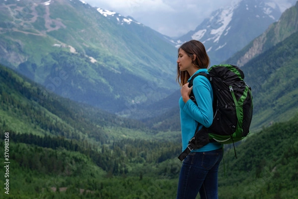 Fototapeta Backpacker on top of a mountain enjoying valley view