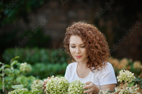 Fototapeta Young woman gardening in the back yard on a sunny spring day