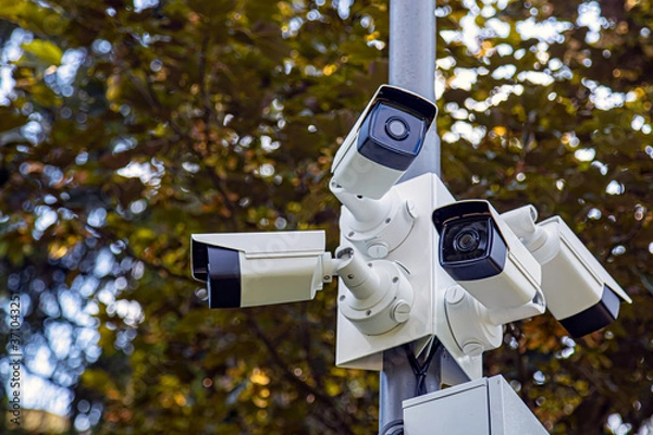 Fototapeta Lamp post with lots of CCTV cameras. Surveillance and modern city security concept.