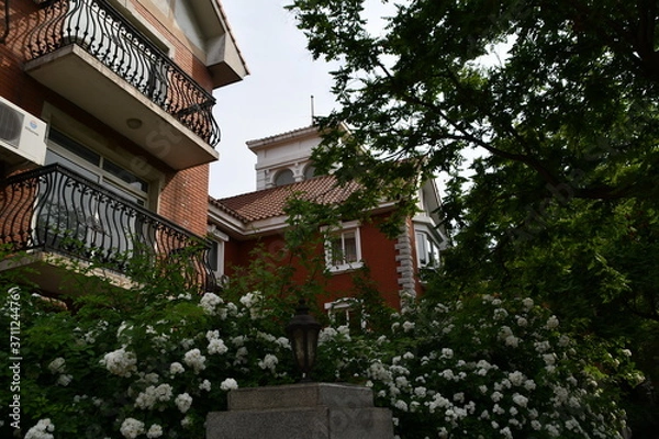 Obraz An old fashioned house in central historical district surrounded by flowers