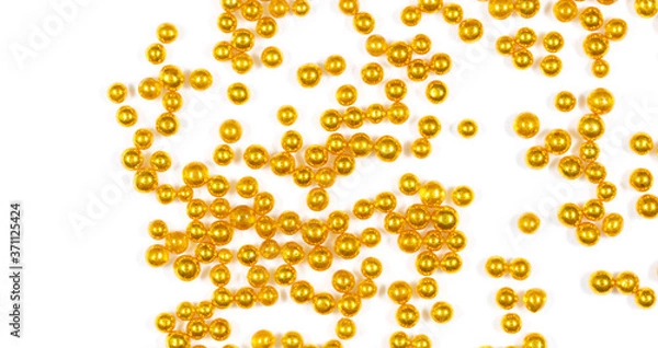 Fototapeta Small balls of gold on a white background.