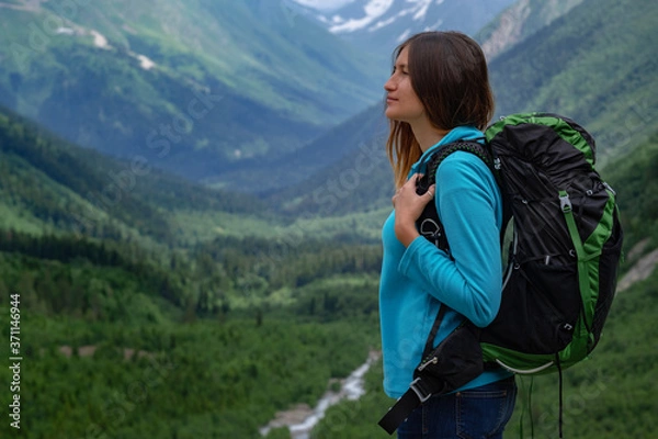 Fototapeta Backpacker on top of a mountain enjoying valley view