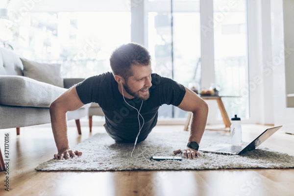 Fototapeta Handsome man working out at home
