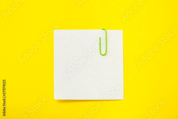 Fototapeta note sheet with paper clip on yellow background