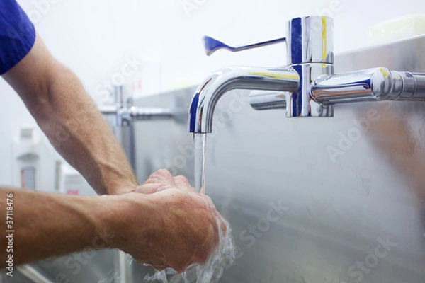 Obraz Surgeon scrubbing hands for operation