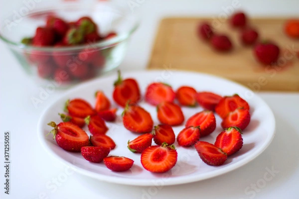 Fototapeta 
Sliced ​​strawberries on  plate on  white background. 
Diet food, vegan menu, homemade cake ingredients.