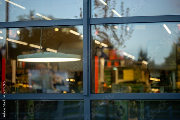 Fototapeta supermarket store windows with lights and advertisements inside