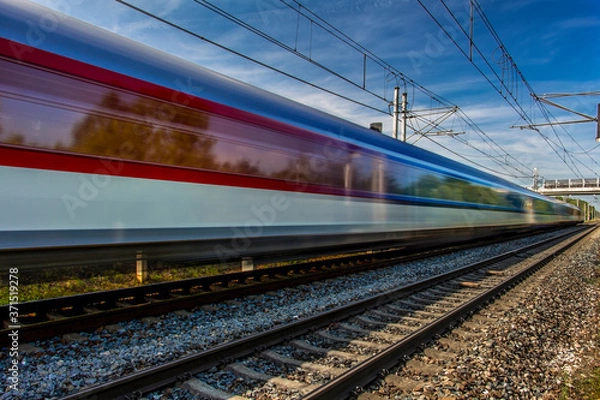 Fototapeta Train in movement by rail with a blue sky