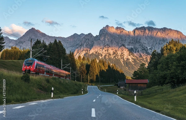 Obraz Rural mountain road near Mittenwald, Bavaria, Germany with Karwendel mountains on background at sunset. Idyllic mountain scene. 