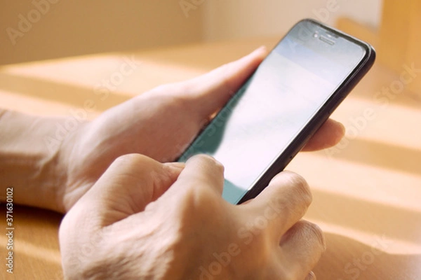 Obraz スマートフォンを操作する男性の手