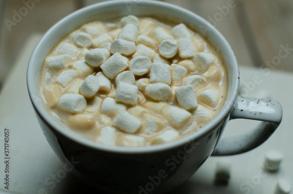 Fototapeta Cup of coffee with marshmallow on books on a wooden background.Slow liwing style background