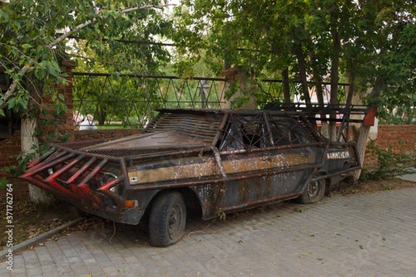 Fototapeta Close-up of a brutal grunge rusty car near a bar in the city of Yarovoe (Altai Territory).