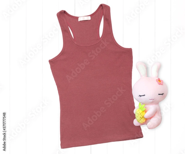 Fototapeta Coral color tank top with soft toy on white background