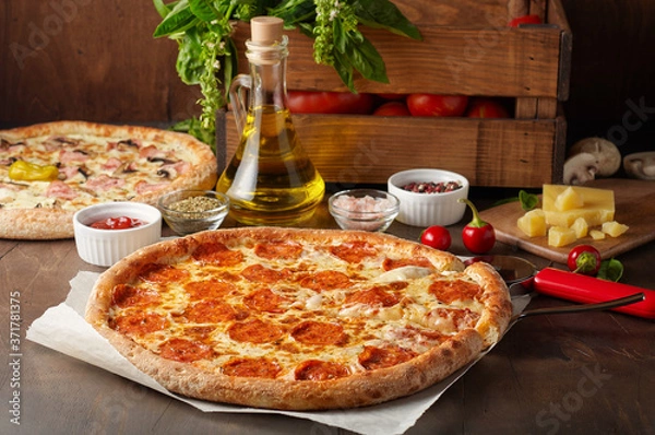 Fototapeta Hot cheese pizza with chorizo on rustic wooden table with ingredients