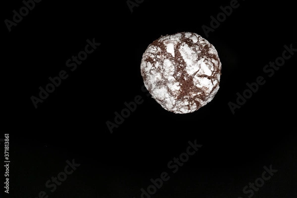Obraz Homemade cookies with chocolate chips with powdered sugar on black background. Freshly baked choco cookie close up. Dark food. Cook at home.