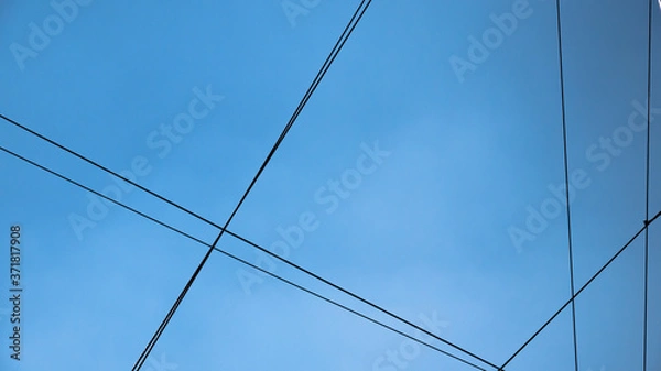 Obraz Six black communication cables crossing with blue sky behind, wire connection 