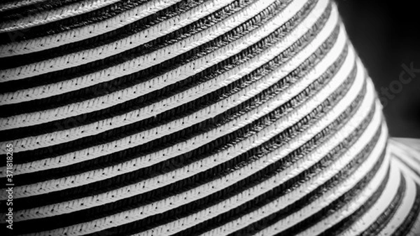 Fototapeta Handcrafted hat with black and white bands, crisscross lines, close-up under sun light