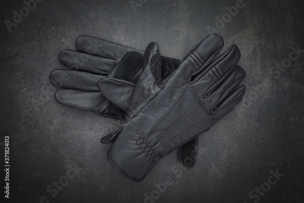 Obraz top view shot a pair of new black leather motorcycle gloves classic style for protect biker hands on dark gray, grey, black tone texture background with copy space for text