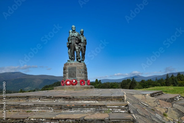 Fototapeta Public Commando Memorial near Spean Bridge, Scottish Highlands. Poppy wreaths at commandos feet. Summer with bright blue sky. Hills in background.