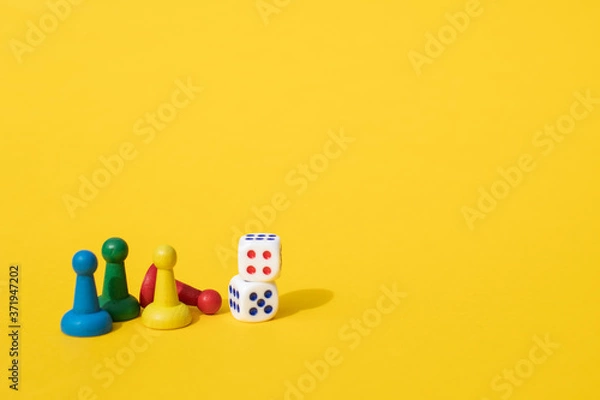 Fototapeta Chess pieces, game chips, Lotto barrels, draughts and playing cubes laid on a yellow background: entertainment, games at home for the whole family, the concept of table games. Board game. Board games