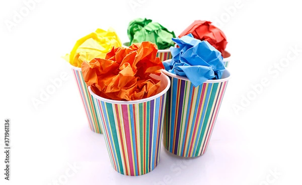 Fototapeta Colored wrinkled paper and paper cup, close up on white background